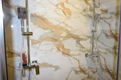 a bathroom with a marble wall with a shower at Супер луксозен апартамент в Winslow in Bansko