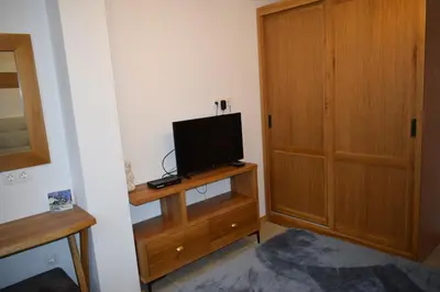 a room with a television on a stand with a wooden door at Супер луксозен апартамент в Winslow in Bansko