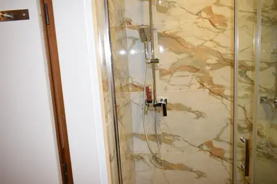 a shower in a bathroom with a stone wall at Супер луксозен апартамент в Winslow in Bansko
