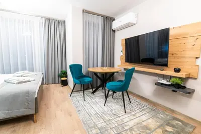 a room with a bed and a table and chairs at Apartmenthaus Oborishte in Panagyurishte