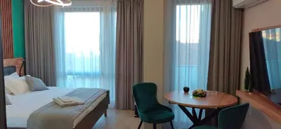 a bedroom with a bed and a table with a chair at Apartmenthaus Oborishte in Panagyurishte