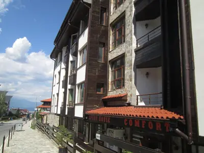 a building with a sign on the side of it at Comfort Private Apartments in Bansko