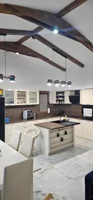 a kitchen with white cabinets and a table and chairs at Relax Srednogorska Panorama in Smolsko