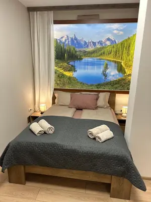 a bedroom with a large picture of a lake and mountains at Apart-Hotel Crown Bansko in Bansko