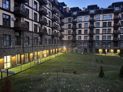 a large apartment building with a grassy yard in front of it at Apart-Hotel Crown Bansko in Bansko