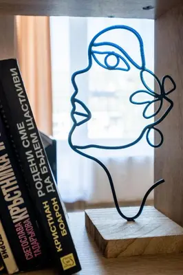 a sculpture of a face next to books at Cozy Homes 1 in Sofia