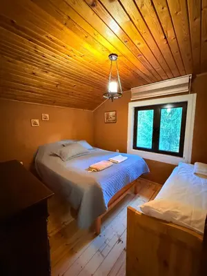 a bedroom with a bed and a window in a cabin at Villa Gusto, 3km from Pamporovo in Pamporovo
