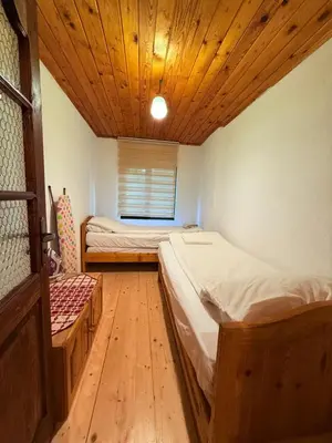 two beds in a room with a wooden ceiling at Villa Gusto, 3km from Pamporovo in Pamporovo