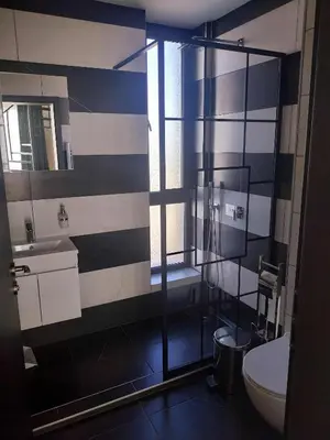 a bathroom with a toilet and a glass shower at Villa Doma in Sapareva Banya
