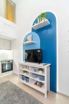 a living room with a tv and a blue wall at Déja Blue Old City Center studio. in Sofia