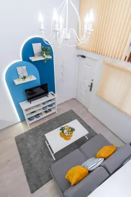 a living room with a rug and a chandelier at Déja Blue Old City Center studio. in Sofia