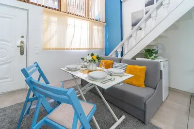 a dining room with a table and chairs and a couch at Déja Blue Old City Center studio. in Sofia