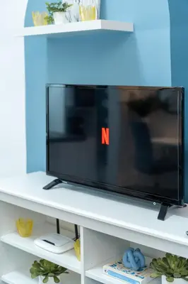 a flat screen tv sitting on a white shelf at Déja Blue Old City Center studio. in Sofia