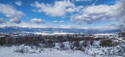 a city covered in snow with mountains in the background at White Сozy Studio A next to the Gondola in Bansko