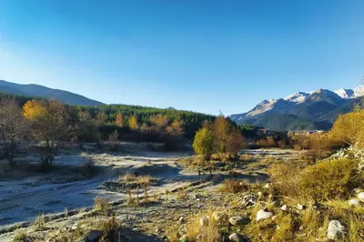 a river in a valley with mountains in the background at White Сozy Studio A next to the Gondola in Bansko