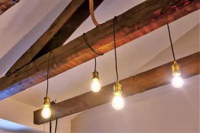 a group of lights hanging from a wooden beam at Artiesta - 5 apartments in Sofia
