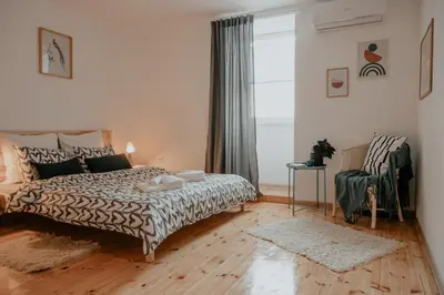 a bedroom with a bed and a chair at Artiesta - 5 apartments in Sofia