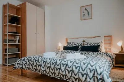 a bedroom with a bed with a black and white comforter at Artiesta - 5 apartments in Sofia