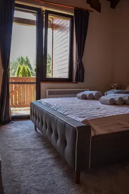 a bedroom with two beds and a large window at Martini villa Lake in Razlog