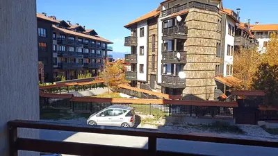 a white car parked on a balcony with buildings at Predela 1 in Bansko