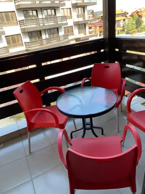 a table and chairs on a balcony with a window at Lorena’s Apartment Bansko,near Gondola in Bansko