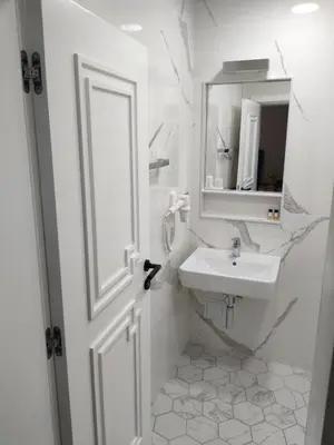 a white bathroom with a sink and a mirror at Luxury rooms 12-2 in Plovdiv