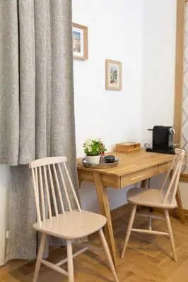 a desk with two chairs next to a wooden table at Luxury rooms 12-2 in Plovdiv