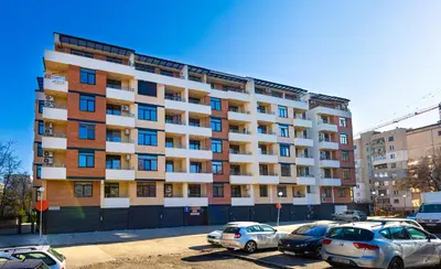 a large apartment building with cars parked in a parking lot at Radiant Retreat - Bright 1BD Haven in Plovdiv by Flat Mаnager in Plovdiv