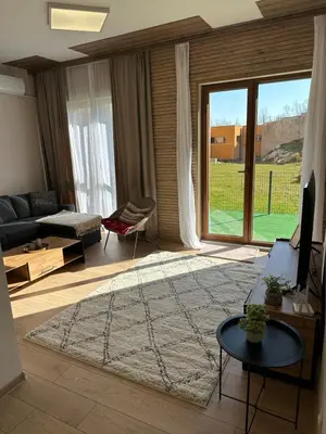 a living room with a couch and a large window at Apart-Hotel Crown Bansko 2 in Bansko