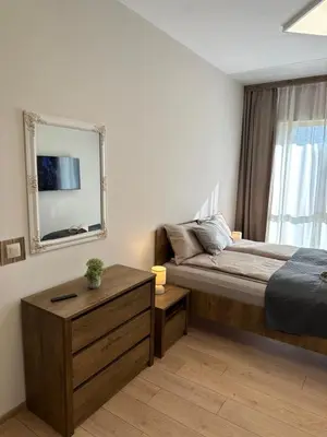 a bedroom with a bed and a mirror and a table at Apart-Hotel Crown Bansko 2 in Bansko