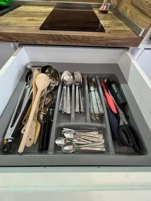 a drawer filled with silver utensils in a drawer at Charming City Apartment SIYANA - Self Check-in in Panagyurishte