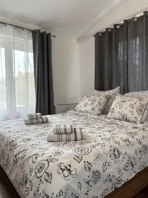 a bed with two pillows on it in a bedroom at Charming City Apartment SIYANA - Self Check-in in Panagyurishte