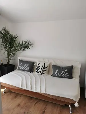 a couch with pillows on it in a living room at Charming City Apartment SIYANA - Self Check-in in Panagyurishte