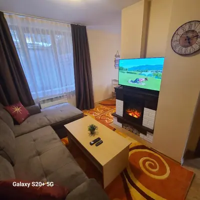 a living room with a couch and a tv and a fireplace at The Castle Bonko in Pamporovo