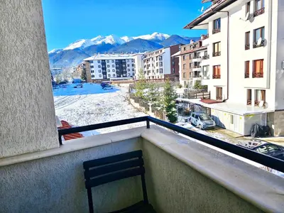 a chair on a balcony with a view of a city at Suite in Dream Bansko in Bansko