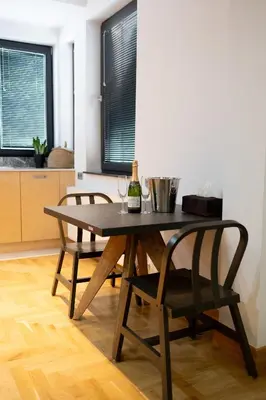 a dining room table with two chairs and a bottle of wine at Luxury room 12-3 in Plovdiv