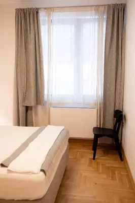 a bedroom with a bed and a window with a chair at Luxury room 12-3 in Plovdiv