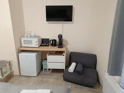 a room with a desk with a chair and a microwave at Студио Орфееви Скали in Pamporovo