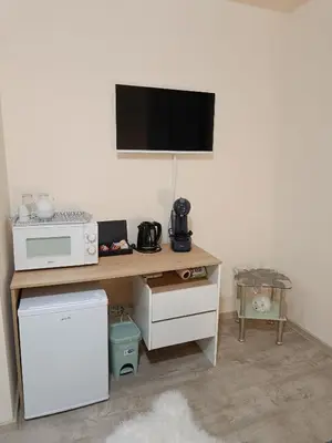 a desk with a microwave and a television on a wall at Студио Орфееви Скали in Pamporovo