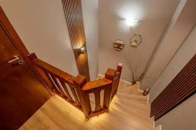 a stairway with a wooden chair and a stair case at Къща за гости В 12 и 5 in Dolna Banya