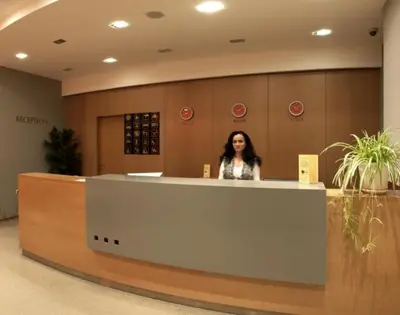 a woman standing behind a counter in a lobby at Studio Villa Park 325 in Borovets