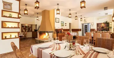 a dining room with a table and a fireplace at Studio Elegance Pamporovo in Pamporovo