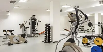a gym with several treadmills and exercise equipment at Studio Elegance Pamporovo in Pamporovo