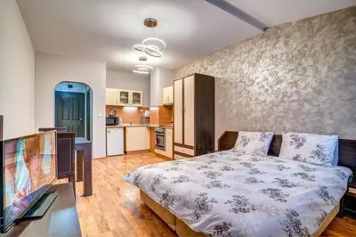 a bedroom with a bed and a kitchen at Студио Ая- Смолянски езера in Smolyan