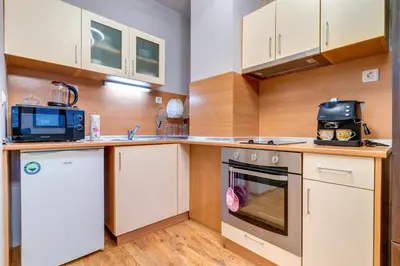 a kitchen with white cabinets and a microwave at Студио Ая- Смолянски езера in Smolyan