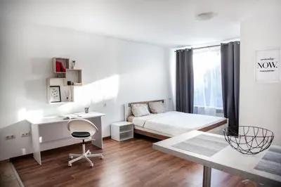 a white bedroom with a bed and a desk at New White Studio F next to Forest the Gondola in Bansko