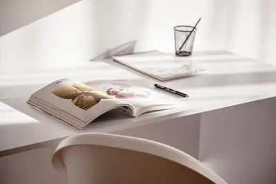 a book on a table with a pen and a glass at New White Studio F next to Forest the Gondola in Bansko
