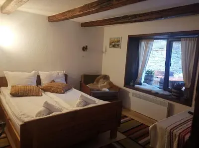 a bedroom with a large bed and a window at Майоровата къща in Shiroka Lŭka