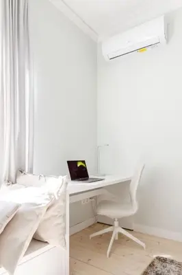 a bedroom with a desk and a bed with a laptop at Sophisticated Gem in the Heart of Sofia in Sofia