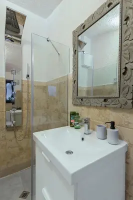 a bathroom with a white sink and a mirror at Dreamy Sunset Loft in Sofia City Center in Sofia